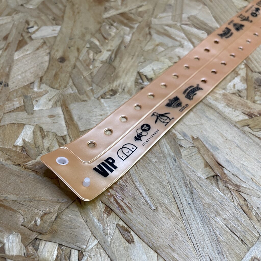 A light brown vinyl security wristband featuring the black "Haven" logo and a white plastic snap closure on a wooden background.